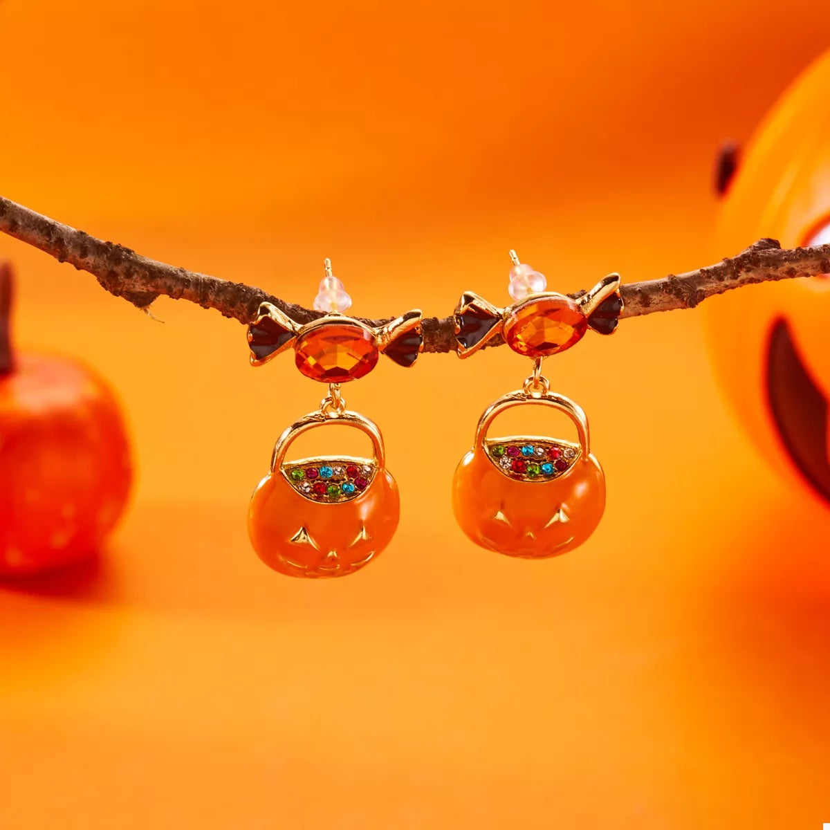 Halloween rhinestone pumpkin dangle earrings with sparkling orange and black accents, featuring a festive pumpkin design.