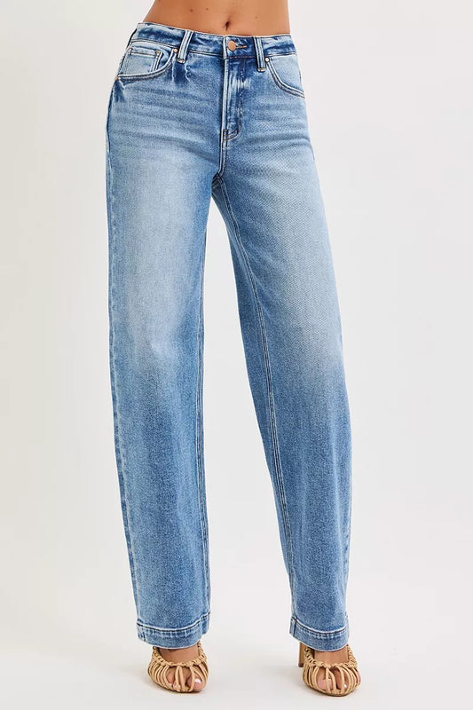 Risen high-rise wide baggy jeans with distressed details and relaxed fit, featuring classic denim texture and stitching.