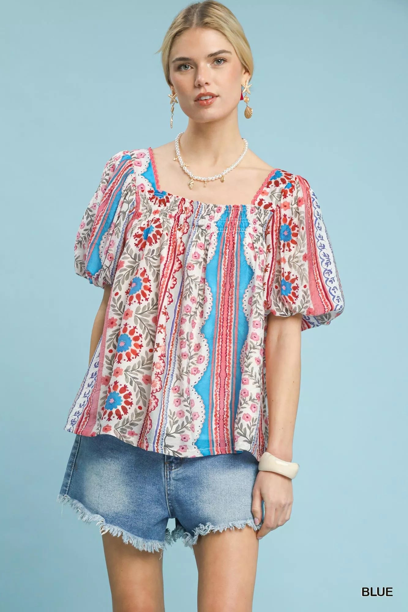 Blue Umgee patchwork puff sleeve smocked blouse with ruffled details, stylish and trendy for casual wear.