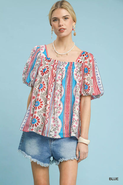 Blue Umgee patchwork puff sleeve smocked blouse with ruffled details, stylish and trendy for casual wear.