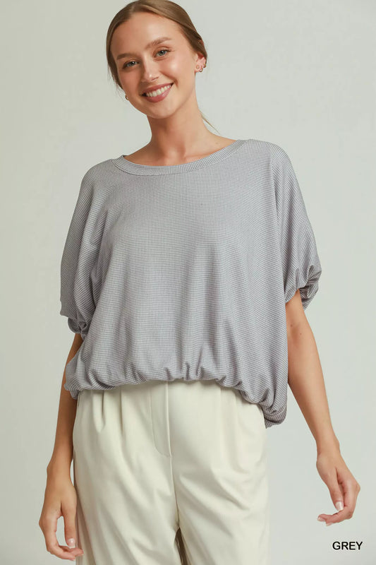 Umgee mini checkered bubble hem top from Trendsi, featuring textured fabric and stylish design, shown in a close-up image.