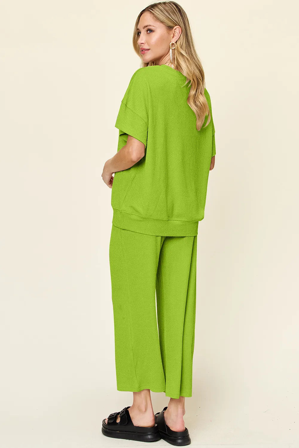 Trendsi Double Take texture round neck short sleeve t-shirt paired with wide-leg pants, showcasing a stylish casual outfit.
