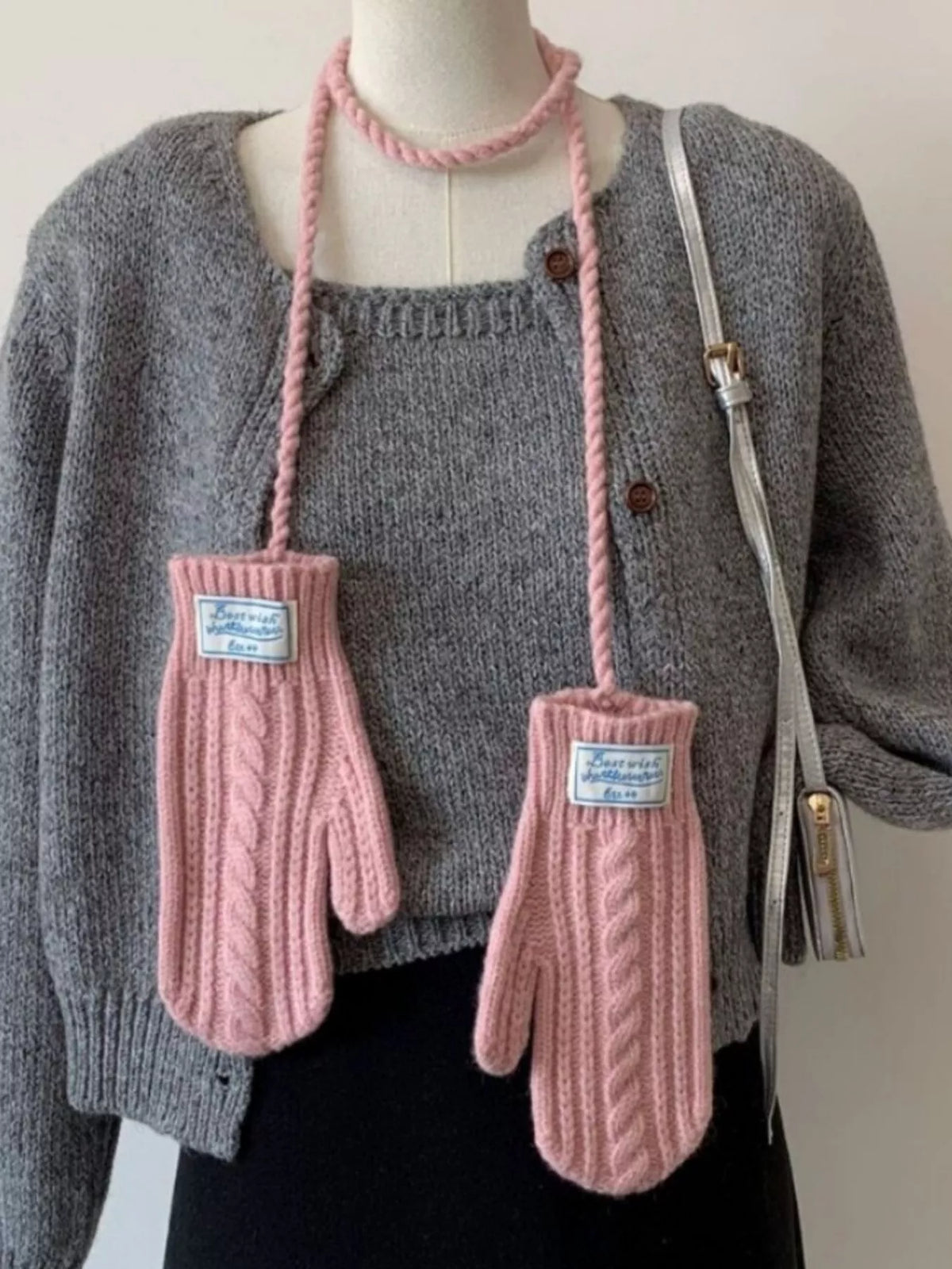 Cable knitted mittens with neck strap from Trendsi, showing cozy, textured wool design and attached strap for warmth and style.