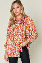 Plus size printed button-up long sleeve shirt from Trendsi, featuring a stylish double take full size design and vibrant pattern.