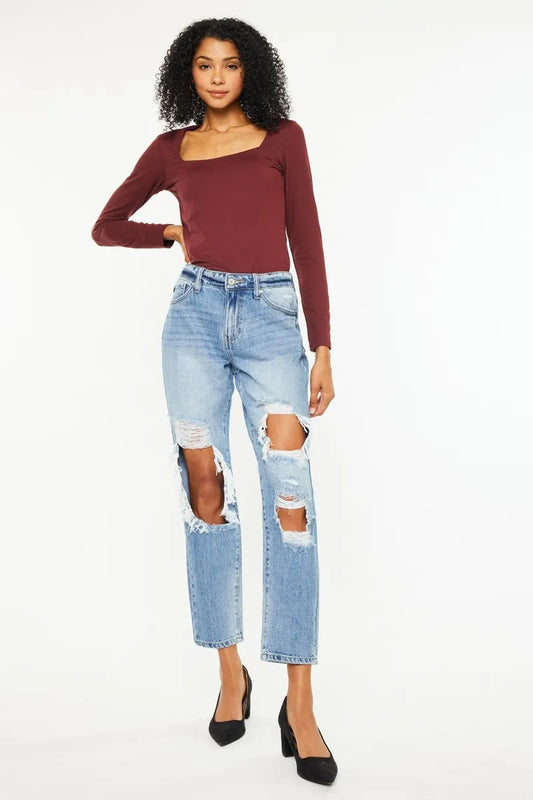 Distressed Kancan high rise boyfriend jeans with a relaxed fit and faded denim, stylishly worn on a female model.