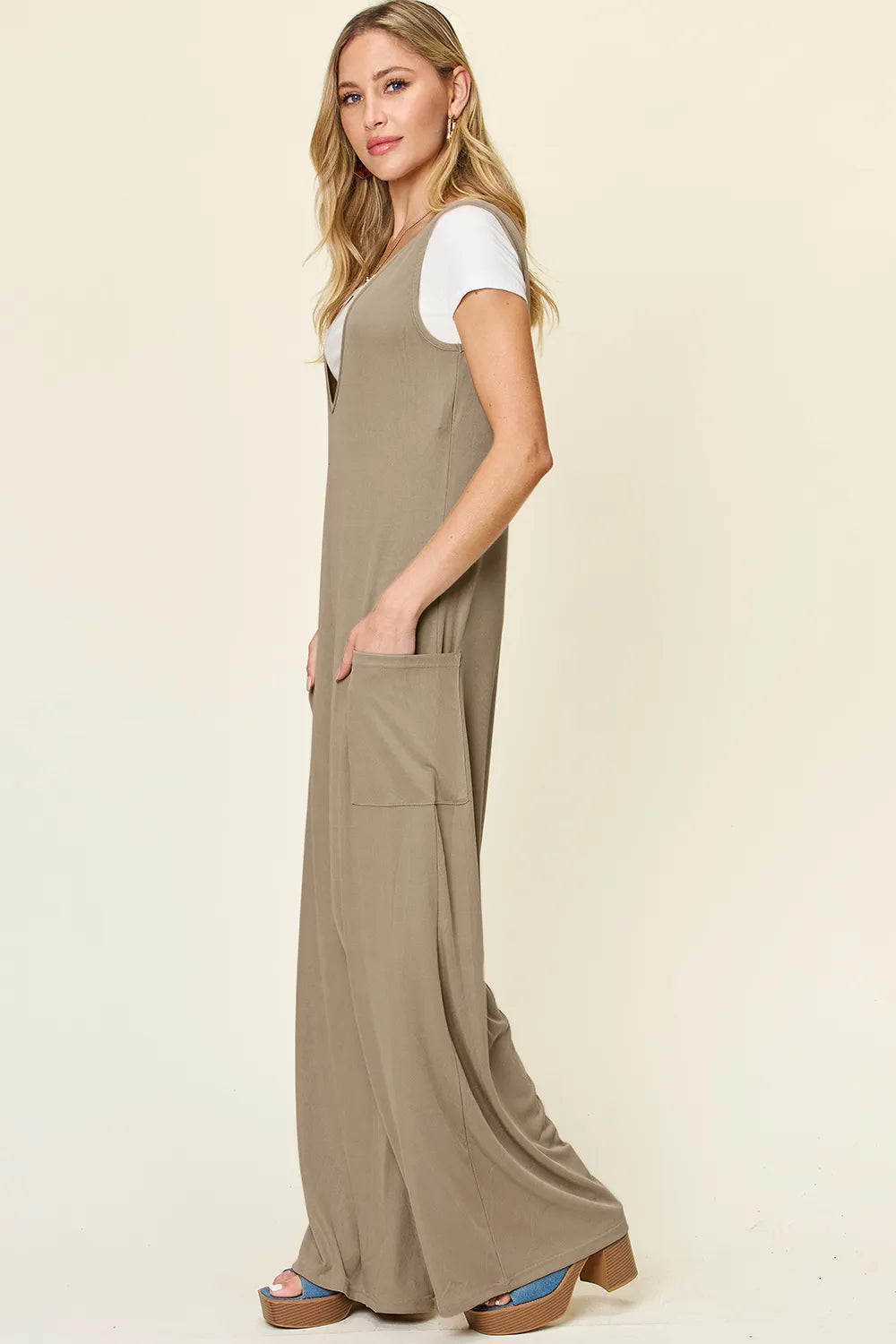 Plus size Trendsi Double Take sleeveless wide-leg jumpsuit with pockets, full length, and a relaxed fit, styled for casual wear.