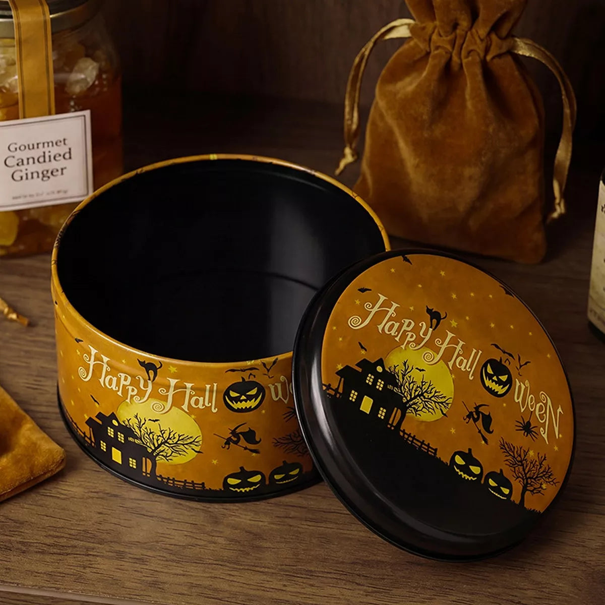 Metal Halloween candy tin with spooky design and handle, decorative storage container for treats, by Trendsi.