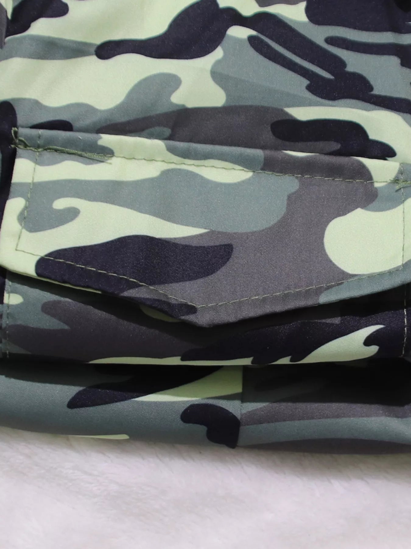 Camouflage button front tie waist romper by Trendsi, featuring short sleeves, front buttons, and a casual fit.