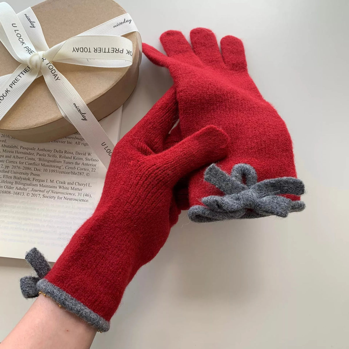 Pink knit gloves with bow decoration from Trendsi, featuring a cozy, stylish design perfect for winter warmth.