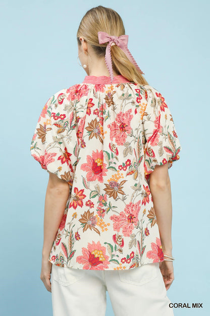 Coral floral puff sleeve blouse by Umgee with a mix of vibrant flower patterns and lightweight fabric, perfect for casual wear.