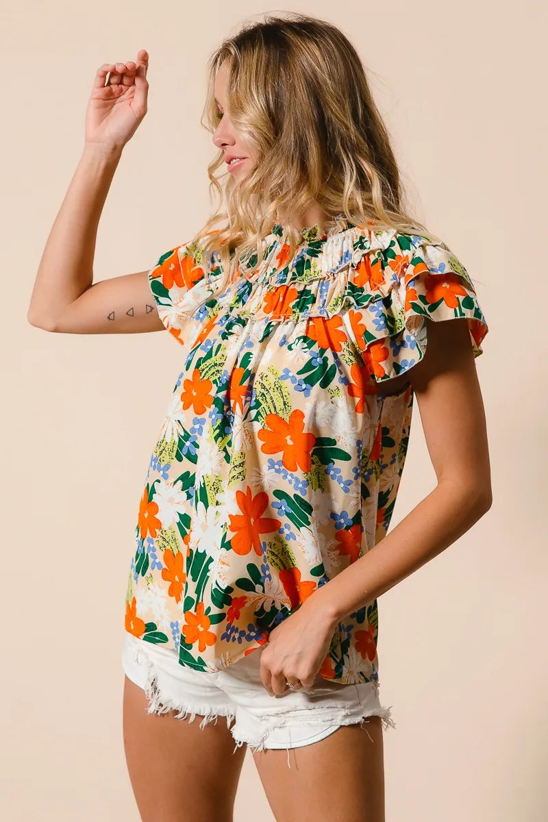 Cream woven top by Trendsi featuring a vibrant multi-color floral print and short sleeves.