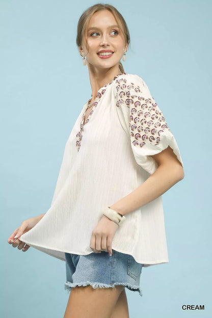 Cream Umgee embroidered sleeve contrast trim top with decorative embroidery on sleeves and stylish trim details.