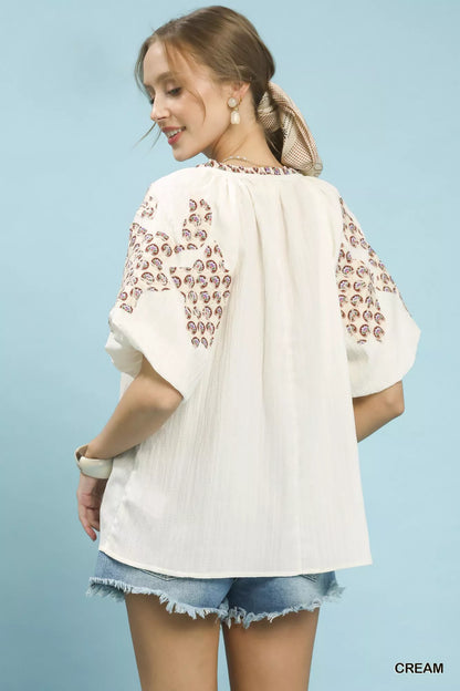 Cream Umgee embroidered sleeve contrast trim top with embroidered details and contrasting trim on sleeves.