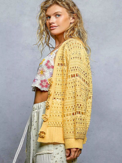 Open-knit floral button cardigan by Trendsi featuring a lightweight, dandelion-inspired pattern and front buttons.