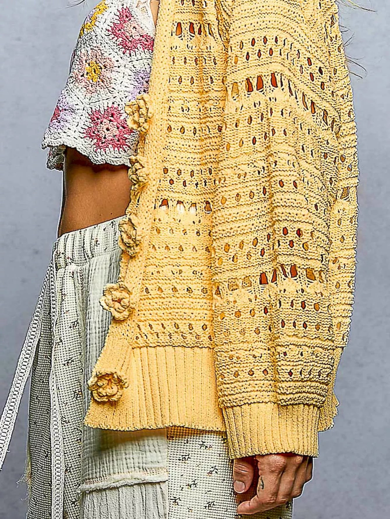 Open-knit floral button cardigan by Trendsi featuring a dandelion pattern, lightweight knit, long sleeves, and button front closure.