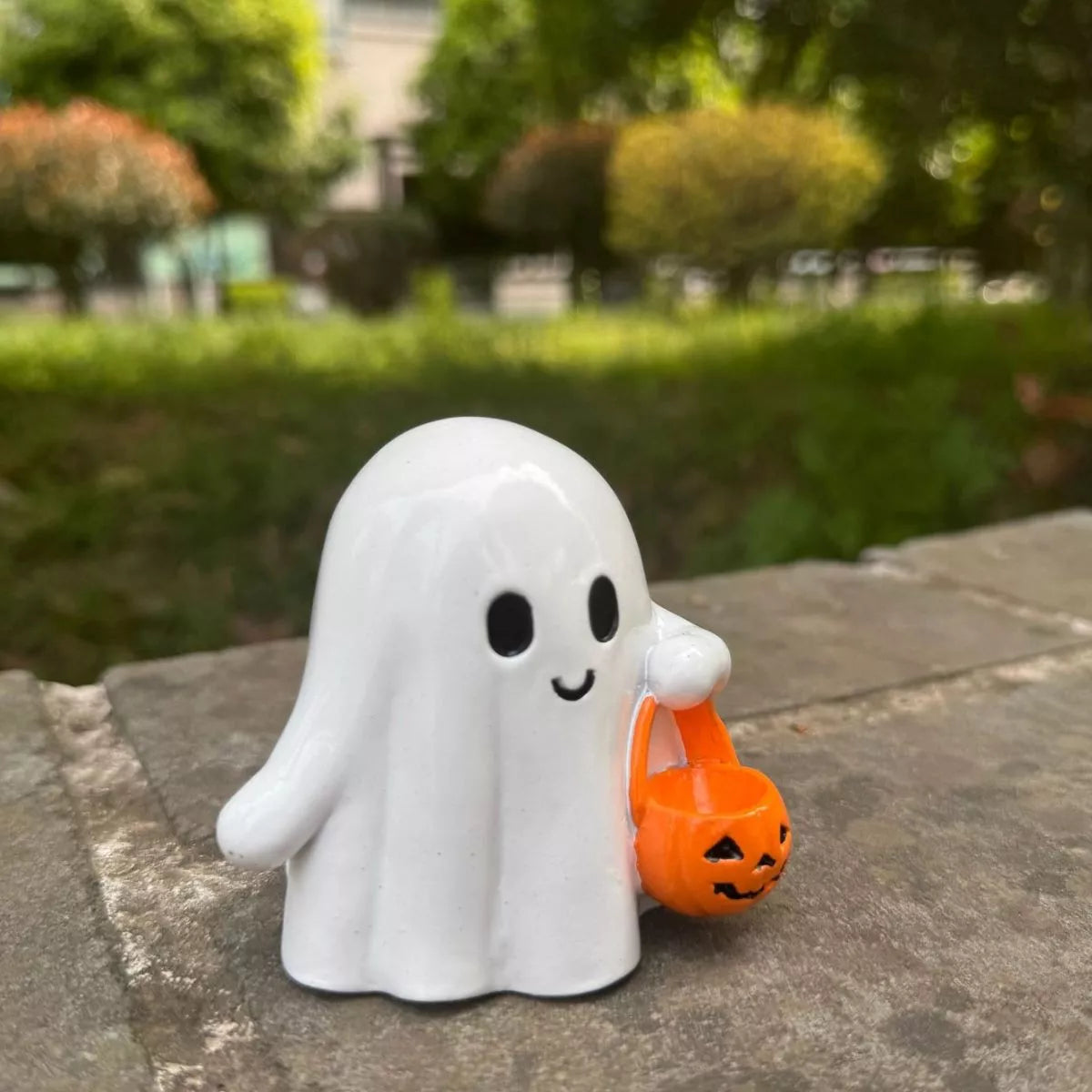 Halloween ghost ornament holding a pumpkin basket, decorative plastic ghost with spooky face for Halloween décor