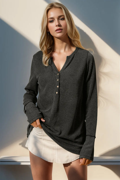 Trendsi double take full size long sleeve T-shirt with notched thumbholes, shown in a close-up of the black fabric and thumbhole design.