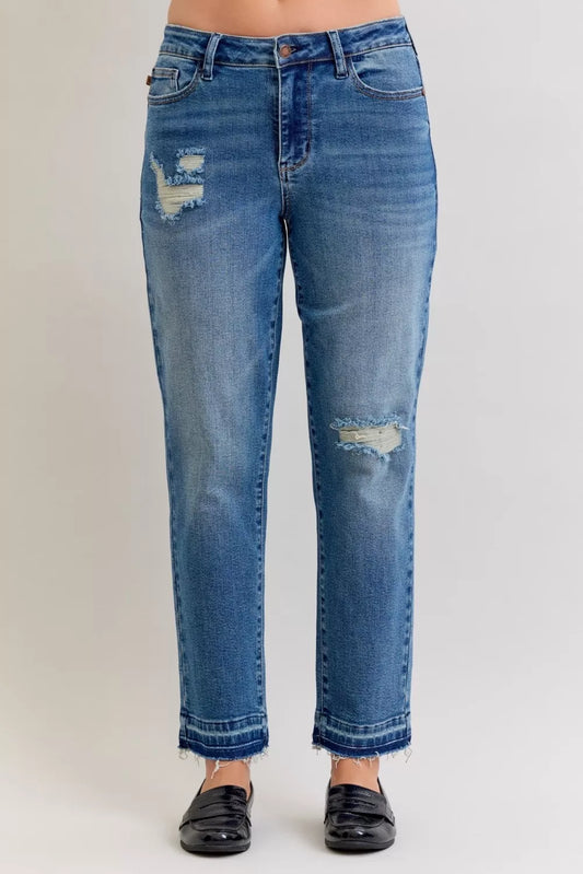 Plus size Judy Blue mid-rise jeans with patch, repair details, distressed finish, and release hem, featuring trendy destruction style.