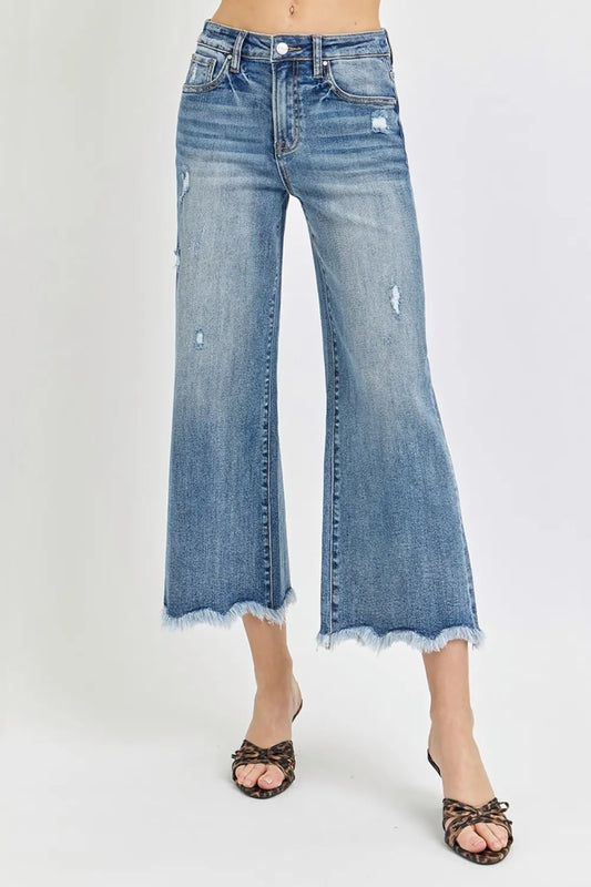 Trendsi Risen high-rise cropped flare jeans showing a fitted waist, flared legs, and distressed details on denim.