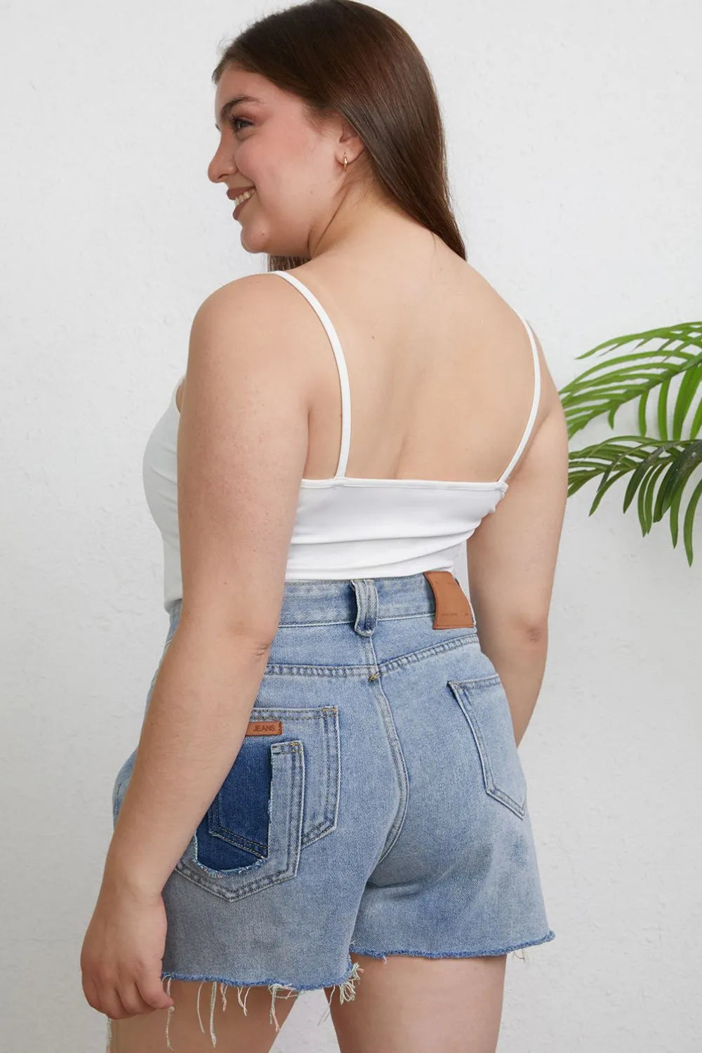 Plus size Basic Bae full size round neck slim cami by Trendsi, featuring a close-up of the black sleeveless top with a rounded neckline.