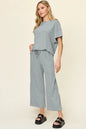 Trendsi Double Take full size textured round neck short sleeve T-shirt and wide-leg pants, showcasing a casual, comfortable outfit.