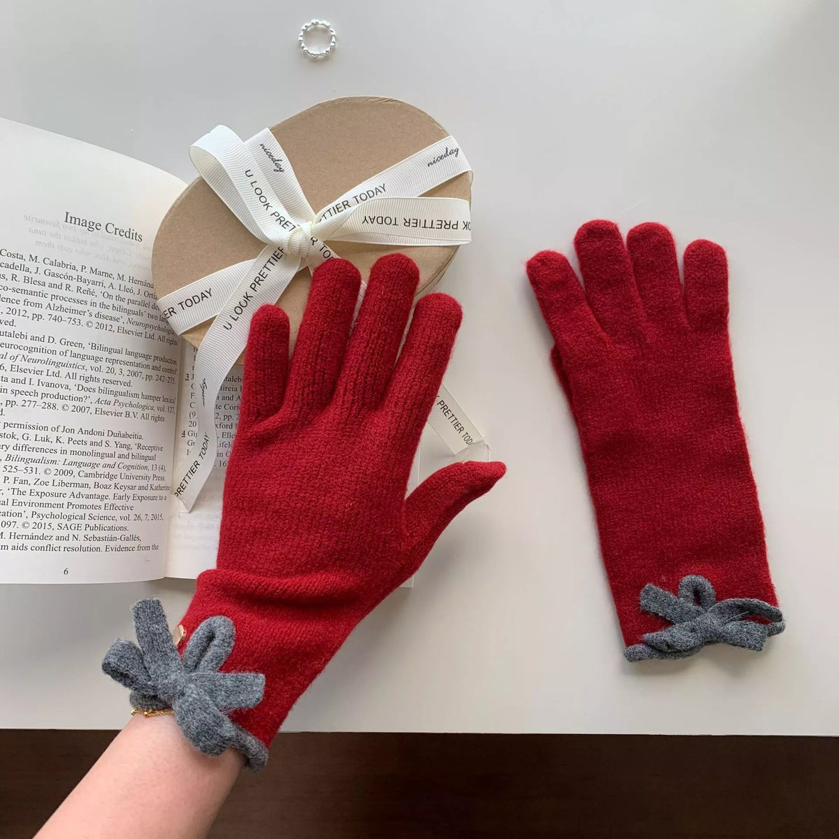 Pink knit gloves with bow decoration, trendy winter accessories from Trendsi, featuring soft fabric and charming design.