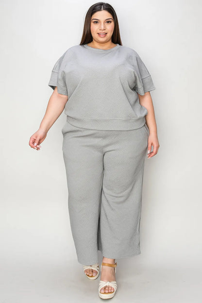 Trendsi Double Take full size textured short sleeve top and matching pants set displayed on a model, casual fashion ensemble.