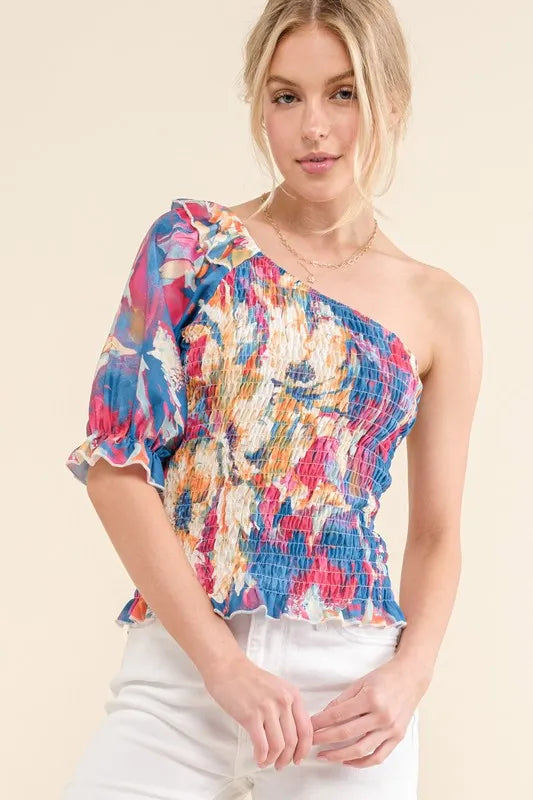 Allover floral print smocked one-shoulder blouse by Trendsi, featuring a stylish and feminine floral design with a relaxed fit.