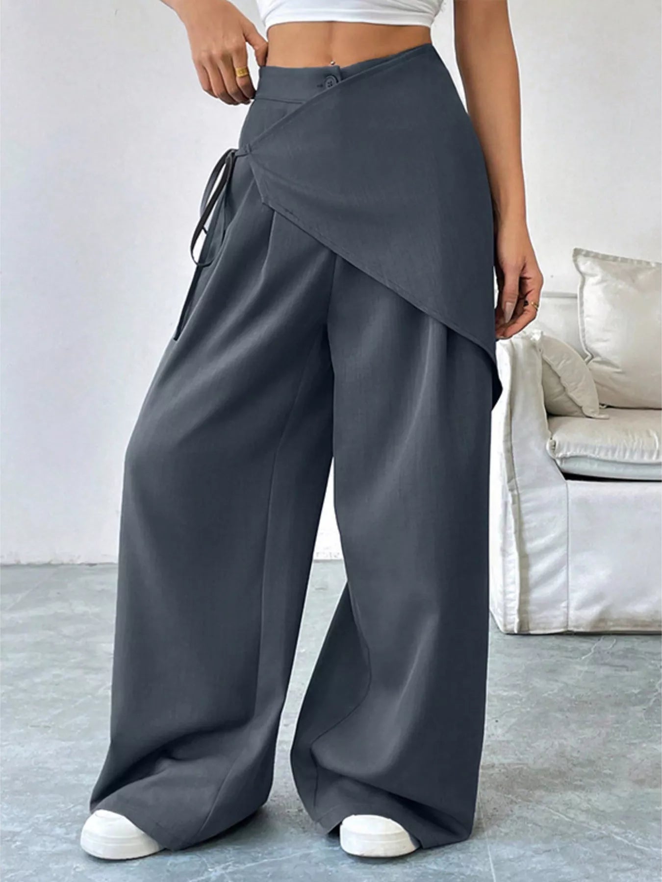 Gray asymmetrical wrap wide-leg pants by Trendsi, shown on a model, featuring flowing fabric and stylish design.