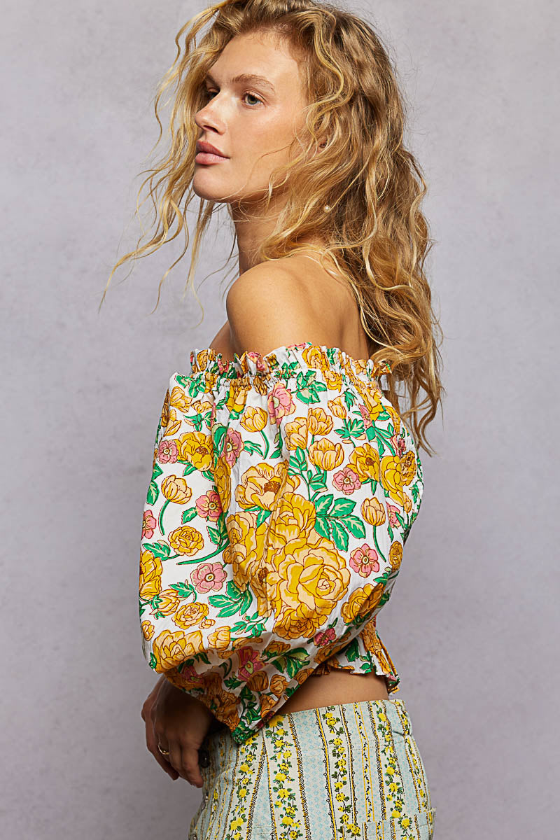 Honey-colored floral print off-shoulder smocked blouse from Trendsi, featuring ruffled neckline and lightweight fabric.