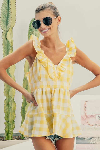 Lemon ivory sleeveless check plaid peplum top with ruffled neckline from Trendsi, showcasing its stylish design and fabric details.