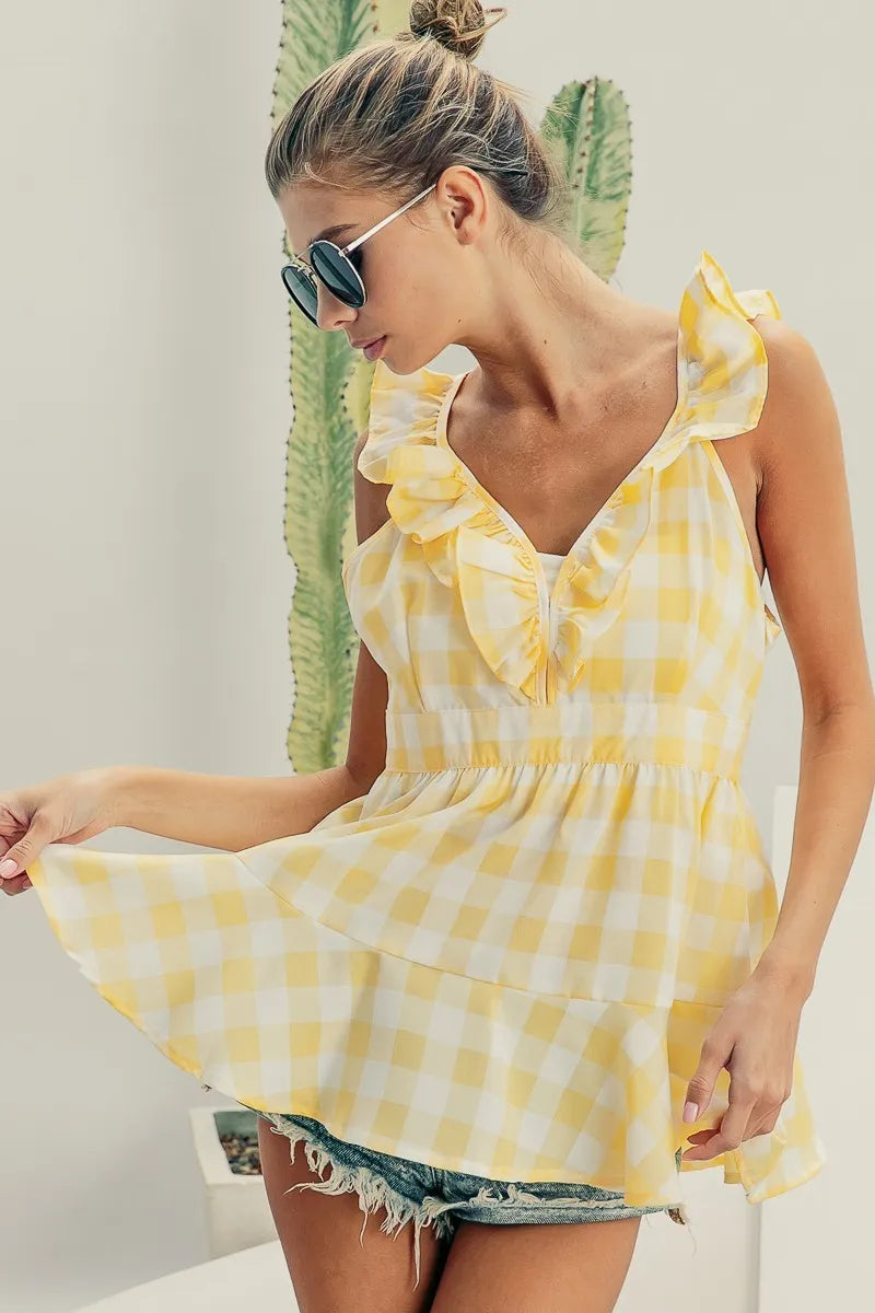 Lemon ivory sleeveless plaid peplum top with ruffled neckline from Trendsi, featuring check pattern and fitted silhouette.