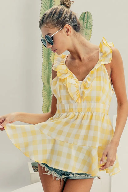 Lemon ivory sleeveless plaid peplum top with ruffled neckline from Trendsi, featuring check pattern and fitted silhouette.