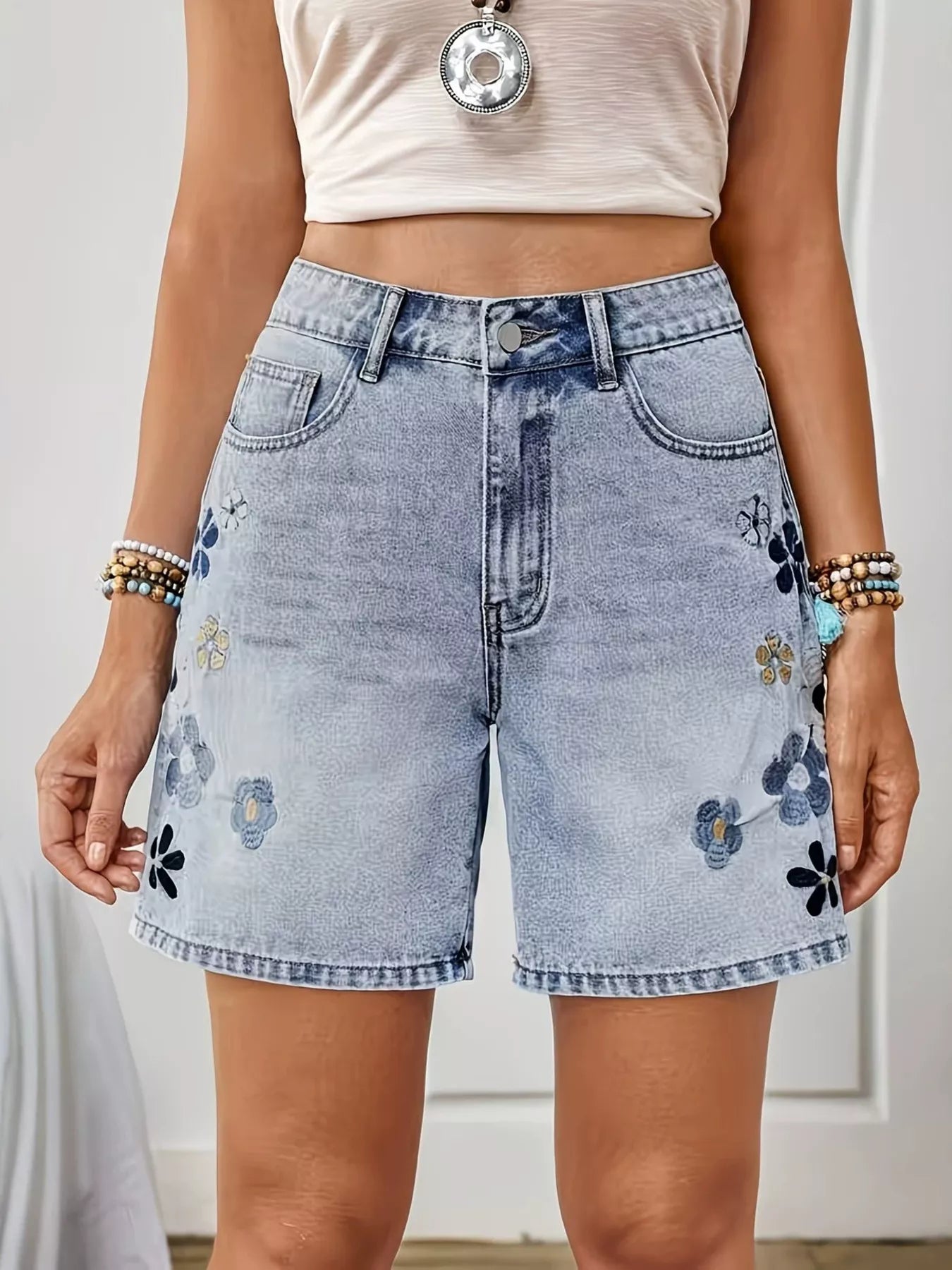Light blue embroidered floral denim shorts from Trendsi, featuring detailed floral embroidery and classic denim design.
