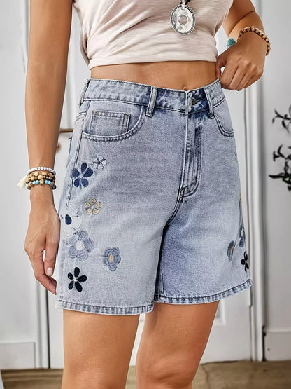 Light blue embroidered floral denim shorts by Trendsi, featuring intricate floral embroidery on classic denim fabric.