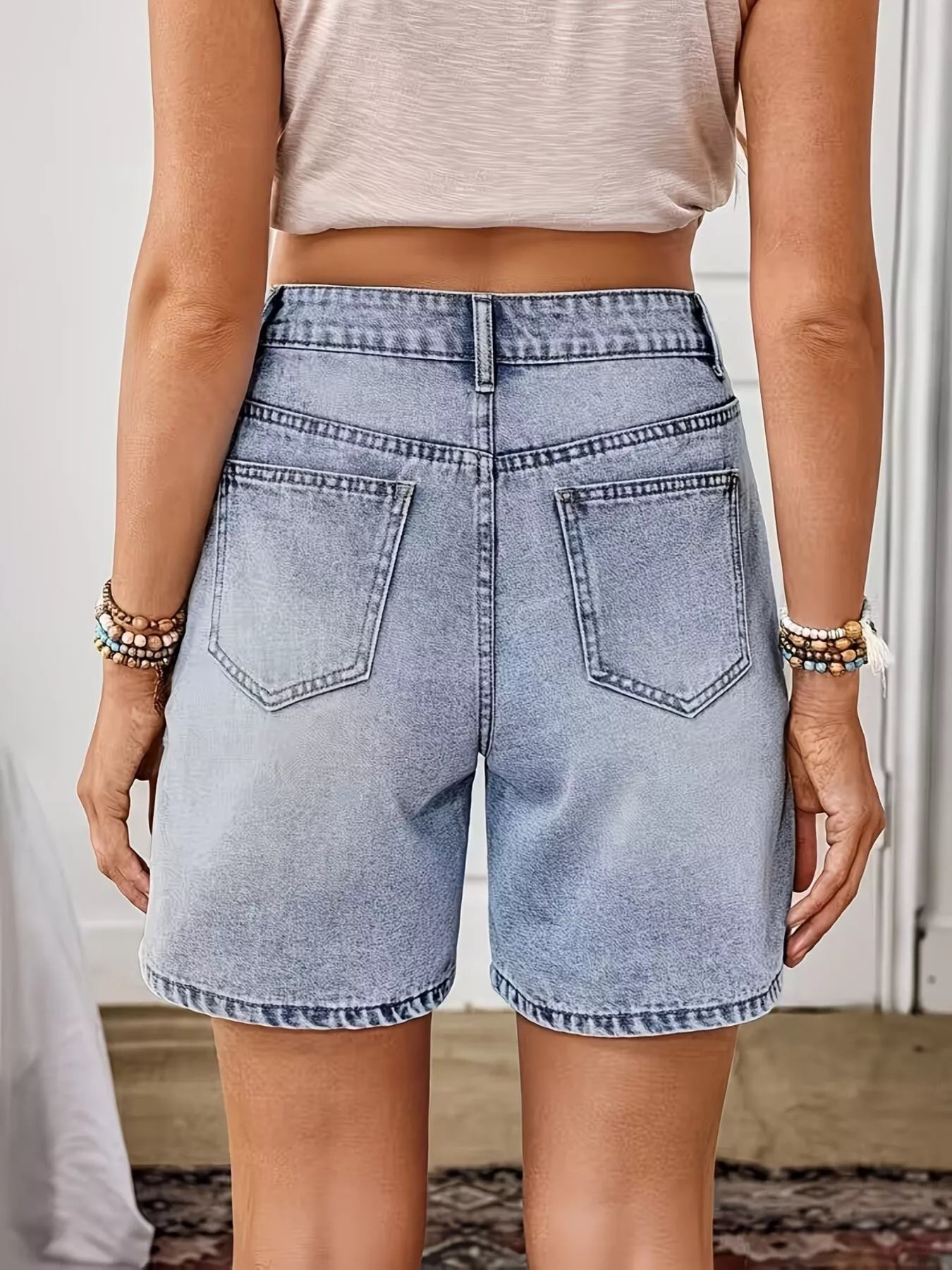Light blue embroidered floral denim shorts by Trendsi, showcasing detailed floral embroidery on classic denim fabric.