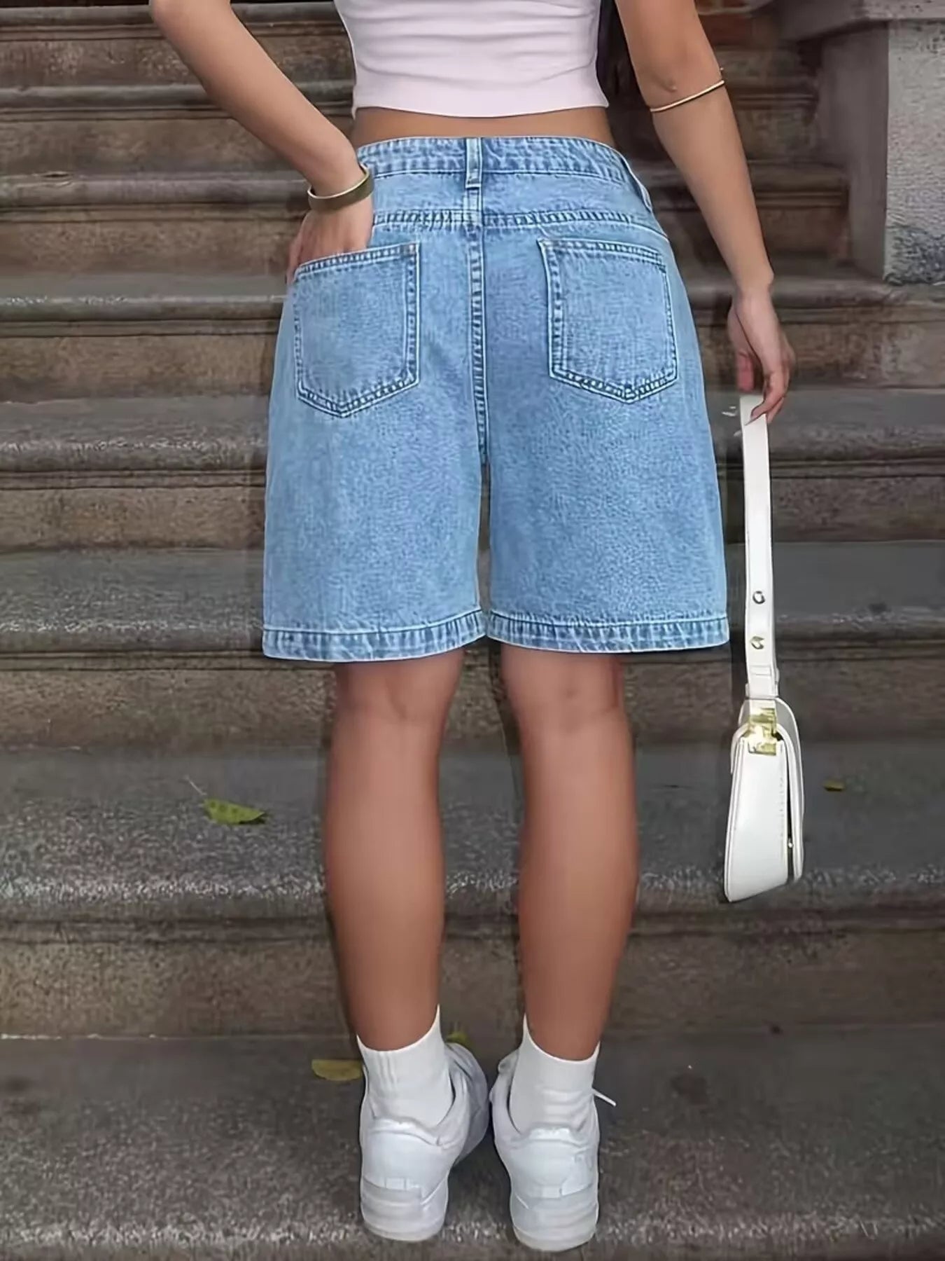 Light blue high waist relaxed fit denim shorts by Trendsi, showcasing a casual style with a comfortable fit and classic denim texture.
