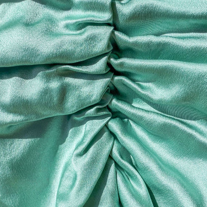 Organic silk hair bonnet in jade green by Lina Lennox, shown covering hair with a smooth, luxurious fabric.