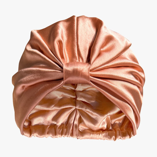Organic silk hair bonnet in peachy coral from LINA LENNOX, designed to protect and gently cover hair during sleep.