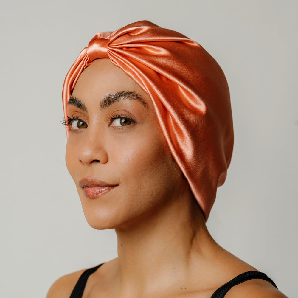 Organic silk hair bonnet in peachy coral by LINA LENNOX, showcasing a soft, smooth fabric designed for gentle hair protection.