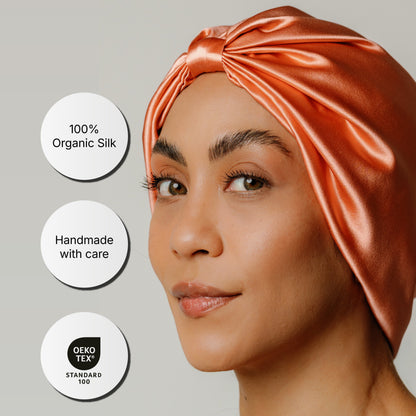 Organic silk hair bonnet in peachy coral by LINA LENNOX, featuring a smooth, luxurious fabric for gentle hair protection.