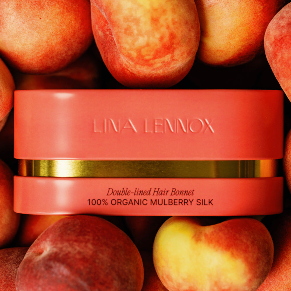 Organic silk hair bonnet in peachy coral by LINA LENNOX, featuring a smooth, luxurious fabric for gentle hair protection.