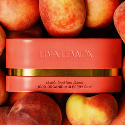 Organic silk hair bonnet in peachy coral by LINA LENNOX, featuring a smooth, luxurious fabric for gentle hair protection.