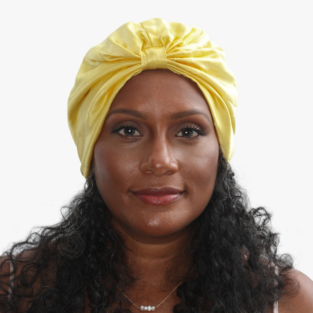LINA LENNOX organic silk hair bonnet in sunshine yellow, soft and smooth, worn on a model's head for gentle hair protection.