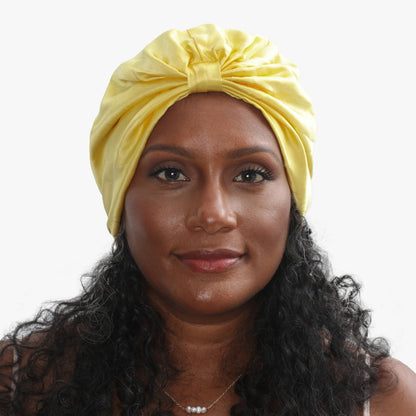 LINA LENNOX organic silk hair bonnet in sunshine yellow, soft and smooth, worn on a model's head for gentle hair protection.