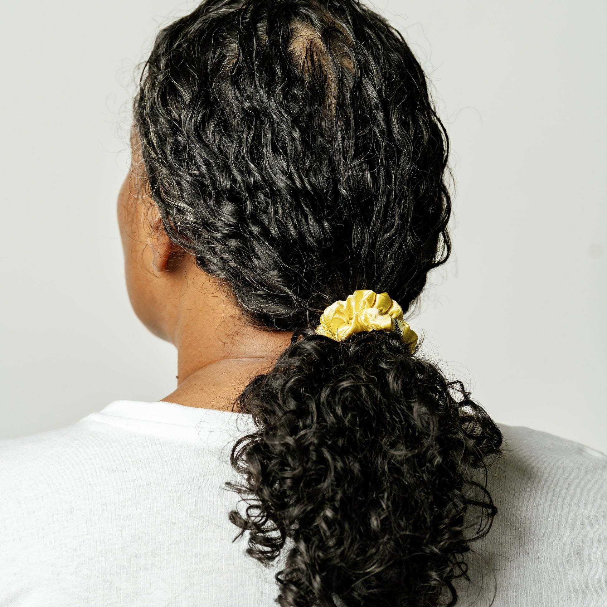 Organic silk small scrunchie in sunshine yellow by LINA LENNOX, featuring a soft, shiny fabric perfect for gentle hair styling.