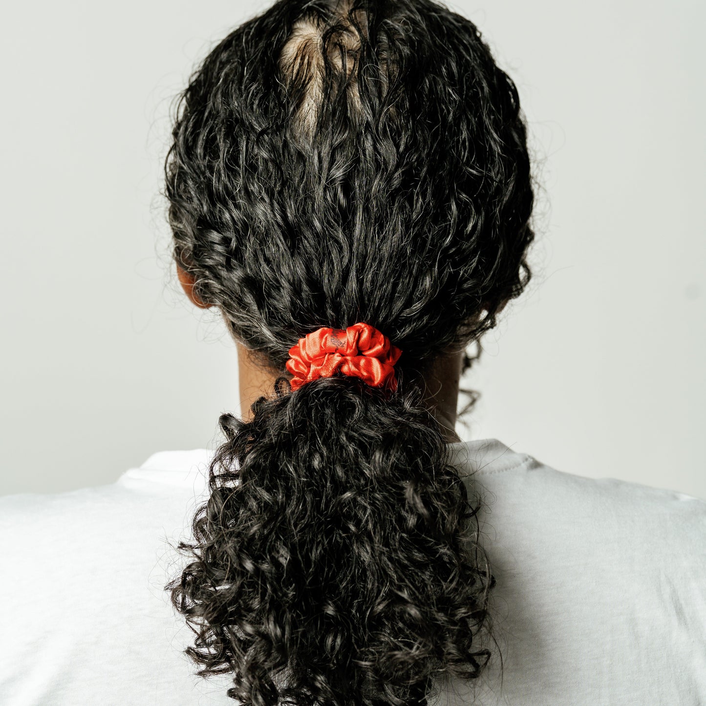 Organic silk small scrunchie in tomato red by LINA LENNOX, soft and stylish hair accessory with a gentle elastic band.