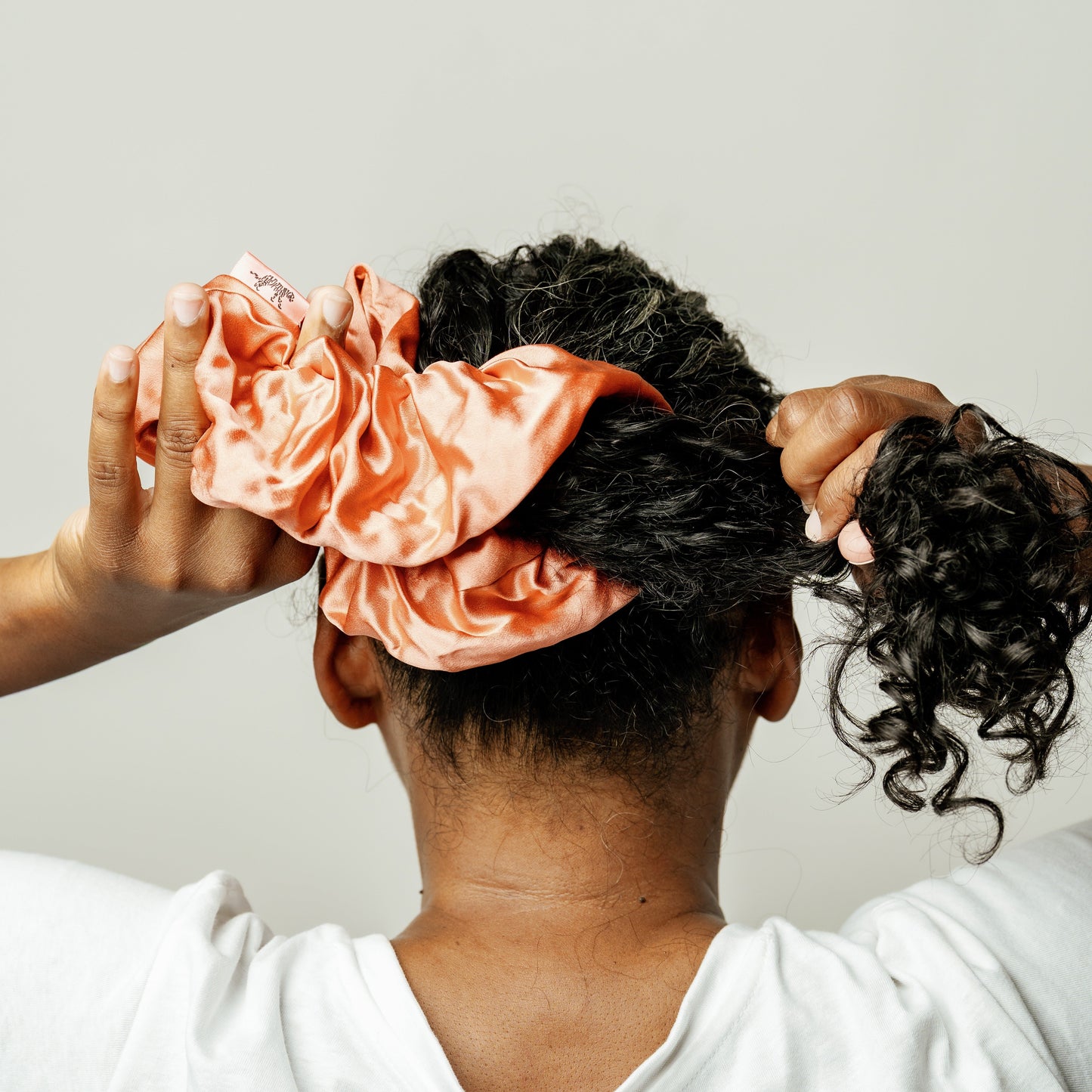 Organic silk oversized scrunchie in peachy coral by LINA LENNOX, soft and luxurious hair accessory featuring a gentle, stylish design.