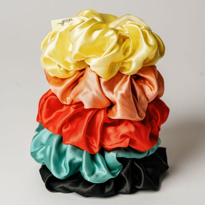 Organic silk oversized scrunchie in peachy coral by LINA LENNOX, showing its soft, luxurious fabric and large, gentle design.