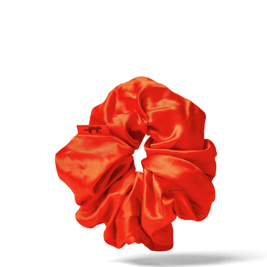 Organic silk oversized scrunchie in vibrant tomato red by LINA LENNOX, shown in a close-up image with soft fabric texture.